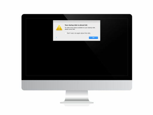 Monitor MacBook, pantalla negra, con letrero que indica que se ha quedado sin espacio de almacenamiento.